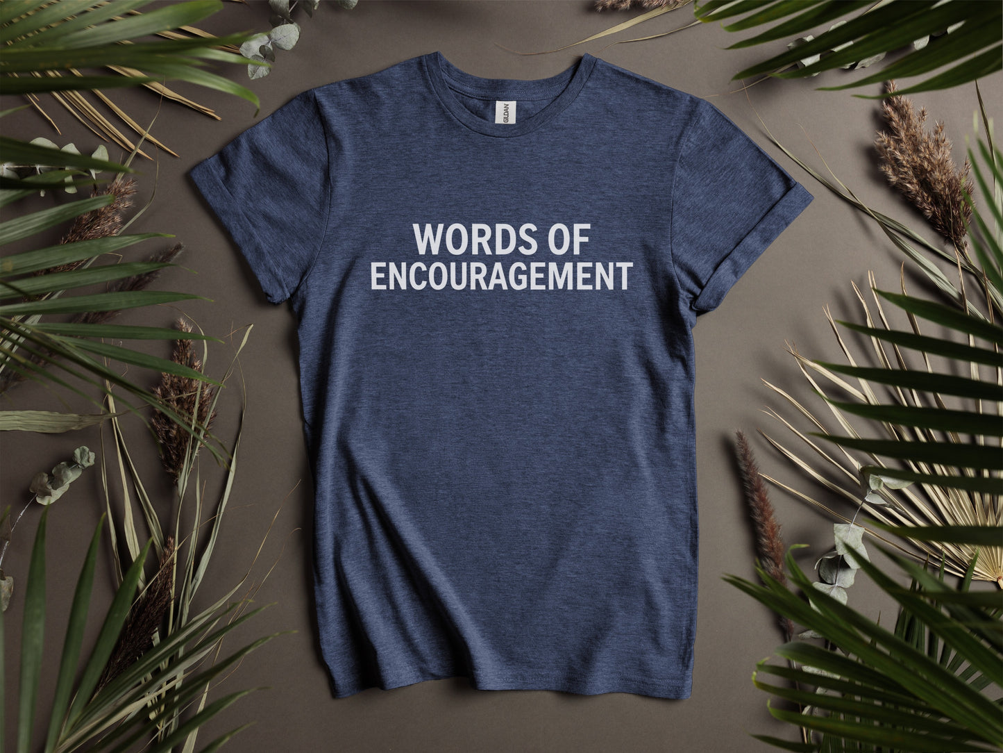 Navy t-shirt with white text "WORDS OF ENCOURAGEMENT" surrounded by foliage.